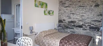 a bedroom with a bed and a stone wall at Paradise Santo Amaro II in Ponta do Sol