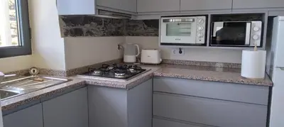 a kitchen with a stove and a microwave at Paradise Santo Amaro II in Ponta do Sol
