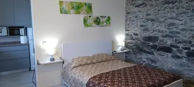 a small bedroom with a bed and a stone wall at Paradise Santo Amaro II in Ponta do Sol