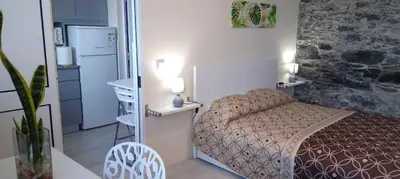 a small bedroom with a bed and a refrigerator at Paradise Santo Amaro II in Ponta do Sol