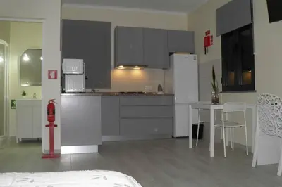 a kitchen with a refrigerator and a table with chairs at Paradise Santo Amaro in Ponta do Sol