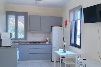 a kitchen with a white refrigerator and a table at Paradise Santo Amaro in Ponta do Sol