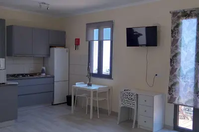 a kitchen with a small table and a white refrigerator at Paradise Santo Amaro in Ponta do Sol
