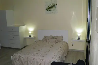 a bedroom with a bed and two lights on two tables at Paradise Santo Amaro in Ponta do Sol