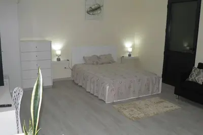 a white bedroom with a bed and a dresser at Paradise Santo Amaro in Ponta do Sol