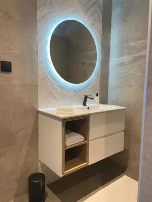 a bathroom with a sink with a round mirror at Casa do Mundo Madeira in Gaula