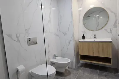 a bathroom with a toilet and a sink and a mirror at Vista Mar The Place by Rentallido in Funchal