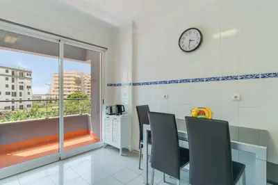 a dining room with a table and chairs and a clock at Gilda Apartment by Atlantic Holiday in Funchal