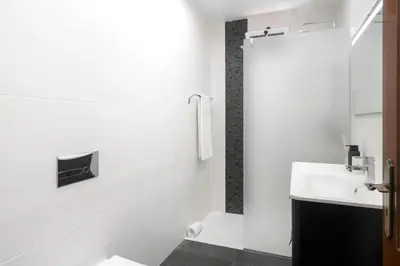 a white bathroom with a sink and a toilet at Casa Coelho in Ponta do Sol