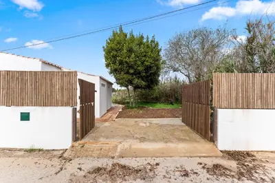 a wooden fence with white doors in a driveway at Da Casa Sesta in Sagres