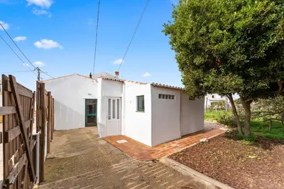 a white house with a tree and a fence at Da Casa Sesta in Sagres