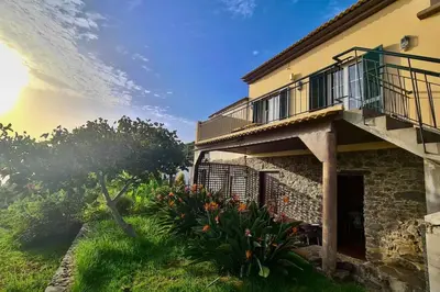 a house with a balcony and some plants at Tranquilidade em Mar e Montanha in Arco da Calheta