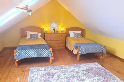 a attic bedroom with two beds and a dresser at Tranquilidade em Mar e Montanha in Arco da Calheta