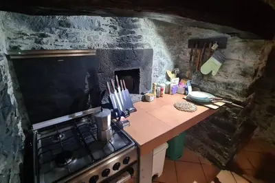 a kitchen with a stove and a counter top at Tranquilidade em Mar e Montanha in Arco da Calheta