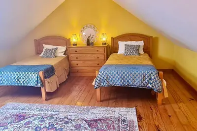 a bedroom with two beds and a dresser at Tranquilidade em Mar e Montanha in Arco da Calheta