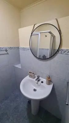 a bathroom with a white sink and a mirror at Tranquilidade em Mar e Montanha in Arco da Calheta