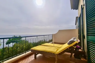 a balcony with a bed and a view of the ocean at Tranquilidade em Mar e Montanha in Arco da Calheta