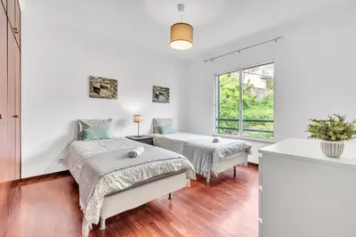 a bedroom with two beds and a window at Apartamento São João in Funchal