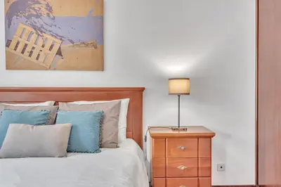a bedroom with a bed with blue pillows and a lamp at Apartamento São João in Funchal