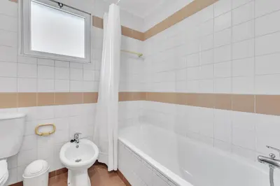 a bathroom with a tub and a toilet and a sink at Apartamento São João in Funchal