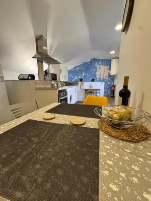 a living room with a large tv and a kitchen at House in the Heart of Funchal with big balcony in Funchal