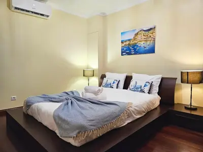 a bedroom with a large white bed with blue pillows at Funchal Old Town Flat 1 in Funchal
