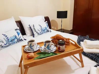 a tray of coffee cups and croissants on a bed at Funchal Old Town Flat 1 in Funchal