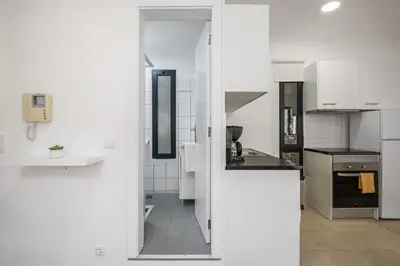 a kitchen with white cabinets and a hallway at Funchal Central Loft by Homie in Funchal