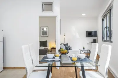 a dining room with a glass table and white chairs at Funchal Central Loft by Homie in Funchal
