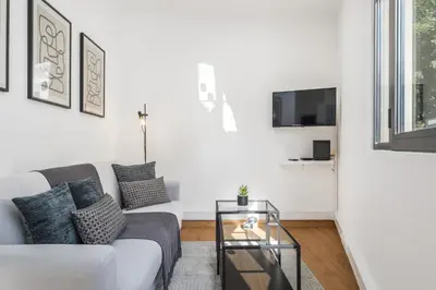 a white living room with a couch and a tv at Funchal Central Loft by Homie in Funchal