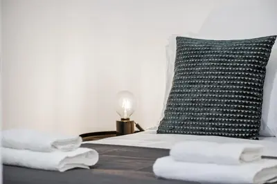 a bed with a black and white pillow and towels at Funchal Central Loft by Homie in Funchal