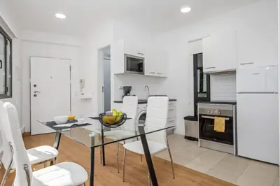 a kitchen and dining room with a glass table and chairs at Funchal Central Loft by Homie in Funchal