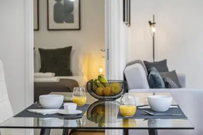 a glass table with a bowl of fruit and two glasses of orange juice at Funchal Central Loft by Homie in Funchal