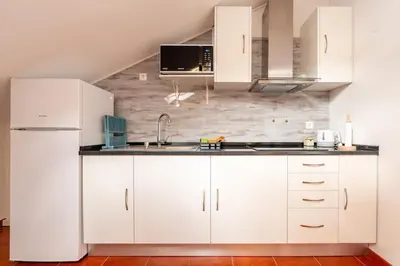 a kitchen with white cabinets and a sink at Ribeiro´s House, New apartment with amazing sunsets in Arco da Calheta