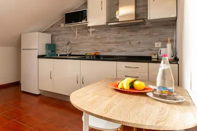 a kitchen with a table with a plate of fruit on it at Ribeiro´s House, New apartment with amazing sunsets in Arco da Calheta