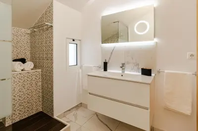 a white bathroom with a sink and a mirror at Ribeiro´s House, New apartment with amazing sunsets in Arco da Calheta