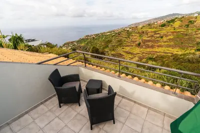 a balcony with chairs and a view of the ocean at Ribeiro´s House, New apartment with amazing sunsets in Arco da Calheta