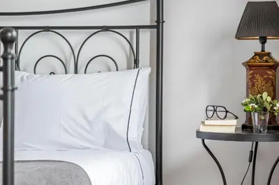 a bedroom with a bed and a table with a lamp at Villa Magnólia in Funchal