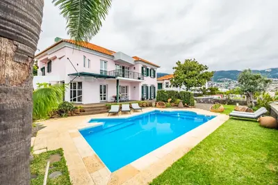 a villa with a swimming pool and a house at Villa Magnólia in Funchal