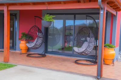 a patio with two wicker chairs and potted plants at Villa Rosa in Porto Moniz