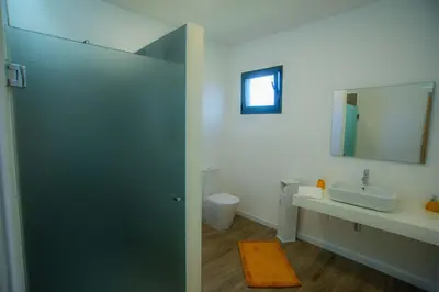 a bathroom with a sink and a toilet and a mirror at Villa Rosa in Porto Moniz