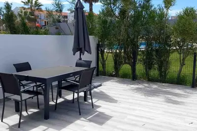 a table and chairs with an umbrella on a patio at Cantinho de Sagres in Sagres