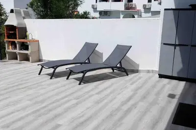 two chairs on a patio with a white wall at Cantinho de Sagres in Sagres
