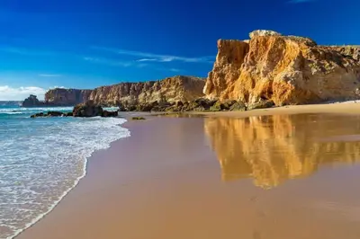 a beach with rocks and the water and the ocean at Cantinho de Sagres in Sagres