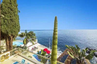 a view of the ocean from a resort with a palm tree at Villa Sea Shore by Villa Plus in Gaula