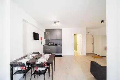 a living room with a table and chairs and a kitchen at JMF Flats in Funchal