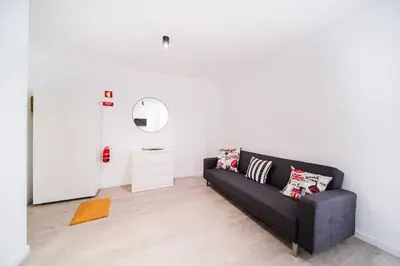 a living room with a black couch and a white wall at JMF Flats in Funchal