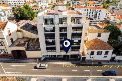 a building with a target sign on it in a city at JMF Flats in Funchal