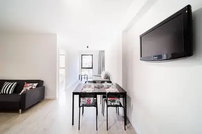 a living room with a table and a tv on a wall at JMF Flats in Funchal