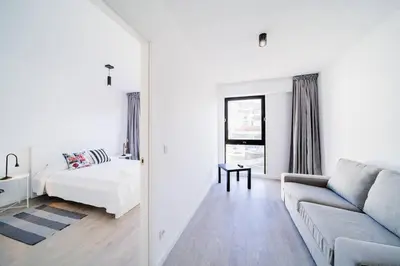 a white living room with a couch and a bed at JMF Flats in Funchal